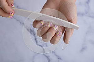 Manicure tools Pastel softness colorful manicured nails. Woman showing her new summer manicure in colors of pastel