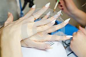 Manicure. The woman cleans and paints nails. The woman processes nails on hands a varnish. Shelak. Gel, a varnish, placing acryle photo