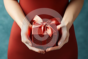 Manicured gesture Womans hands delicately hold a red gift