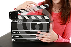 Manicured hands holding film slate