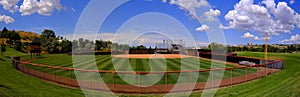 Manicured Mowed Grass on Baseball Field Diamond with Blue Sky and Clouds