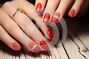 Manicured nails colored with red nail polish