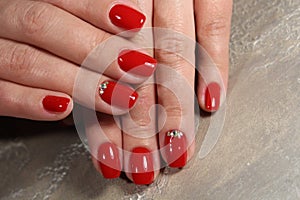 Manicured nails colored with red nail polish
