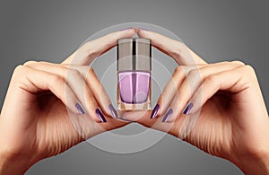 Manicured nails with lilac nail polish. Manicure with bright nailpolish. Fashion manicure. Shiny gel lacquer in bottle