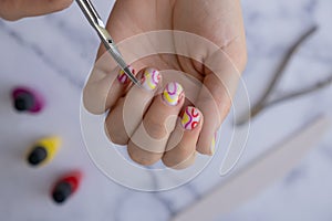 Manicured scissors Stylish colorful summer female nails. Modern trendy stylish Beautiful manicure. Cute pastel nail