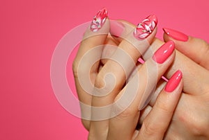 Manicured woman`s nails with pink nailart with flowers. photo