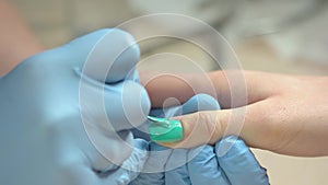 Manicurist accurately applying nail varnish.