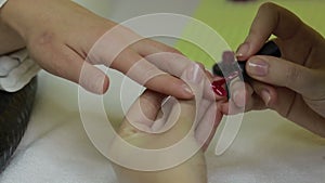Manicurist applying gel polish on fingernail