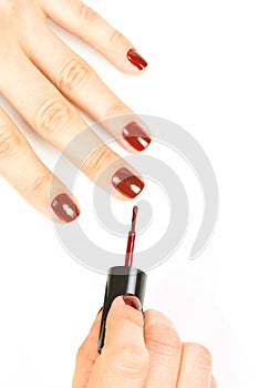 Manicurist applying red nail polish