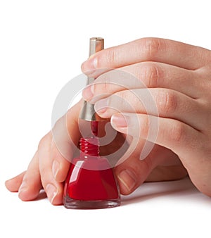 Manicurist applying red nail polish on female fing
