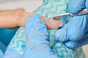 Manicurist cleaning nails to female client.