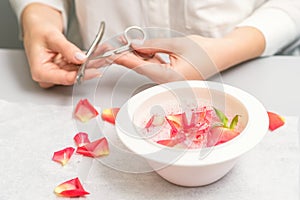 Manicurist decorates bowl with petals