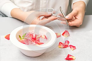 Manicurist decorates bowl with petals