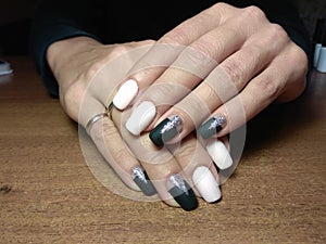 The manicurist excellently made her work a beautiful manicure with a polish gel on her hands and the client is happy