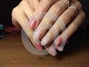 The manicurist excellently made her work a beautiful manicure with a polish gel on her hands and the client is happy