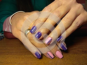 The manicurist excellently made her work a beautiful manicure with a polish gel on her hands and the client is happy