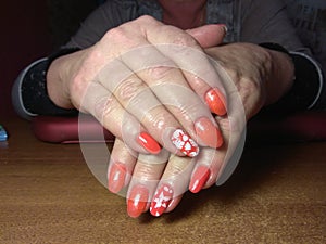 The manicurist excellently made her work a beautiful manicure with a polish gel on her hands and the client is happy