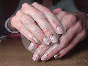 The manicurist excellently made her work a beautiful manicure with a polish gel on her hands and the client is happy