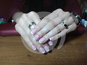 The manicurist excellently made her work a beautiful manicure with a polish gel on her hands and the client is happy