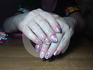 The manicurist excellently made her work a beautiful manicure with a polish gel on her hands and the client is happy