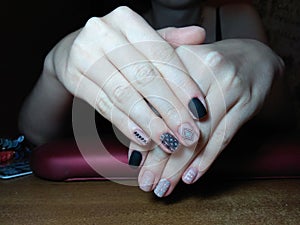 The manicurist excellently made her work a beautiful manicure with a polish gel on her hands and the client is happy