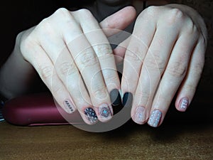 The manicurist excellently made her work a beautiful manicure with a polish gel on her hands and the client is happy