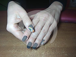 The manicurist excellently made her work a beautiful manicure with a polish gel on her hands and the client is happy