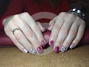 The manicurist excellently made her work a beautiful manicure with a polish gel on her hands and the client is happy