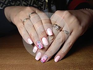 The manicurist excellently made her work a beautiful manicure with a polish gel on her hands and the client is happy