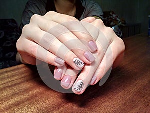 The manicurist excellently made her work a beautiful manicure with a polish gel on her hands and the client is happy