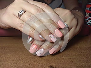 The manicurist excellently made her work a beautiful manicure with a polish gel on her hands and the client is happy