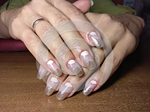 The manicurist excellently made her work a beautiful manicure with a polish gel on her hands and the client is happy