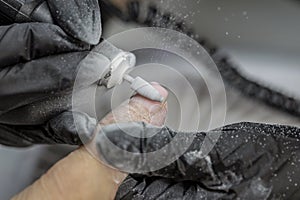 Manicurist fixing nails of a client