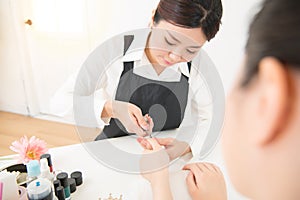 Manicurist hands cutting cuticle on nails