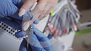 Manicurist master removing cuticles with manicure scissors