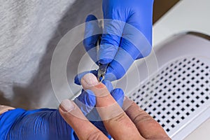 Manicurist master removing cuticles with manicure scissors