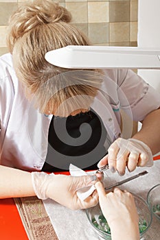 Manicurist removing cuticles