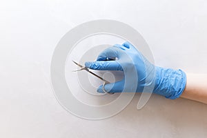 Manicurist`s hand holds manicure scissors