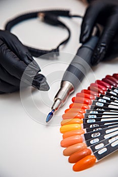 a manicurist\'s hands, a cutter and nail polish samples