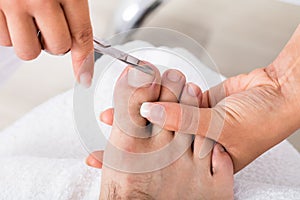 Manicurist With Scissors Trimming Person`s Toenail