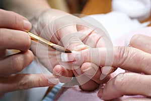 Manicurist treating customer