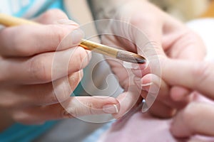 Manicurist treating customer