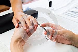 Manicurist trimming a clients cuticles photo