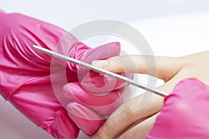 Manicurist uses a manicure nail file to process nail plate and nail file