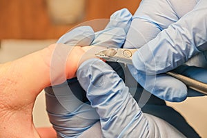 Manicurist uses nippers during manicure procedure.