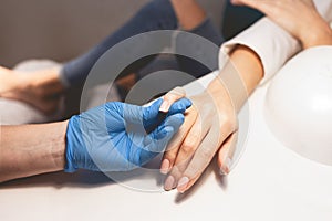 Manicurist varnishes the client`s nails, making french style. Manicure process close up