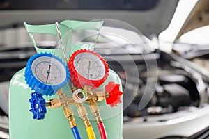 Manifold tool gauge bucket refrigerant applies to car air conditioning with blurred technician repairman check car air