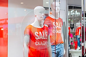 Manikens with sale sign in a shop