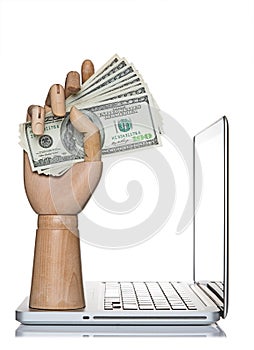 Manikin hand holding money on a computer laptop