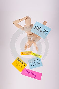 Manikin jointed doll holding a Help picket sign sticky notes SEO ranking keywords website photo